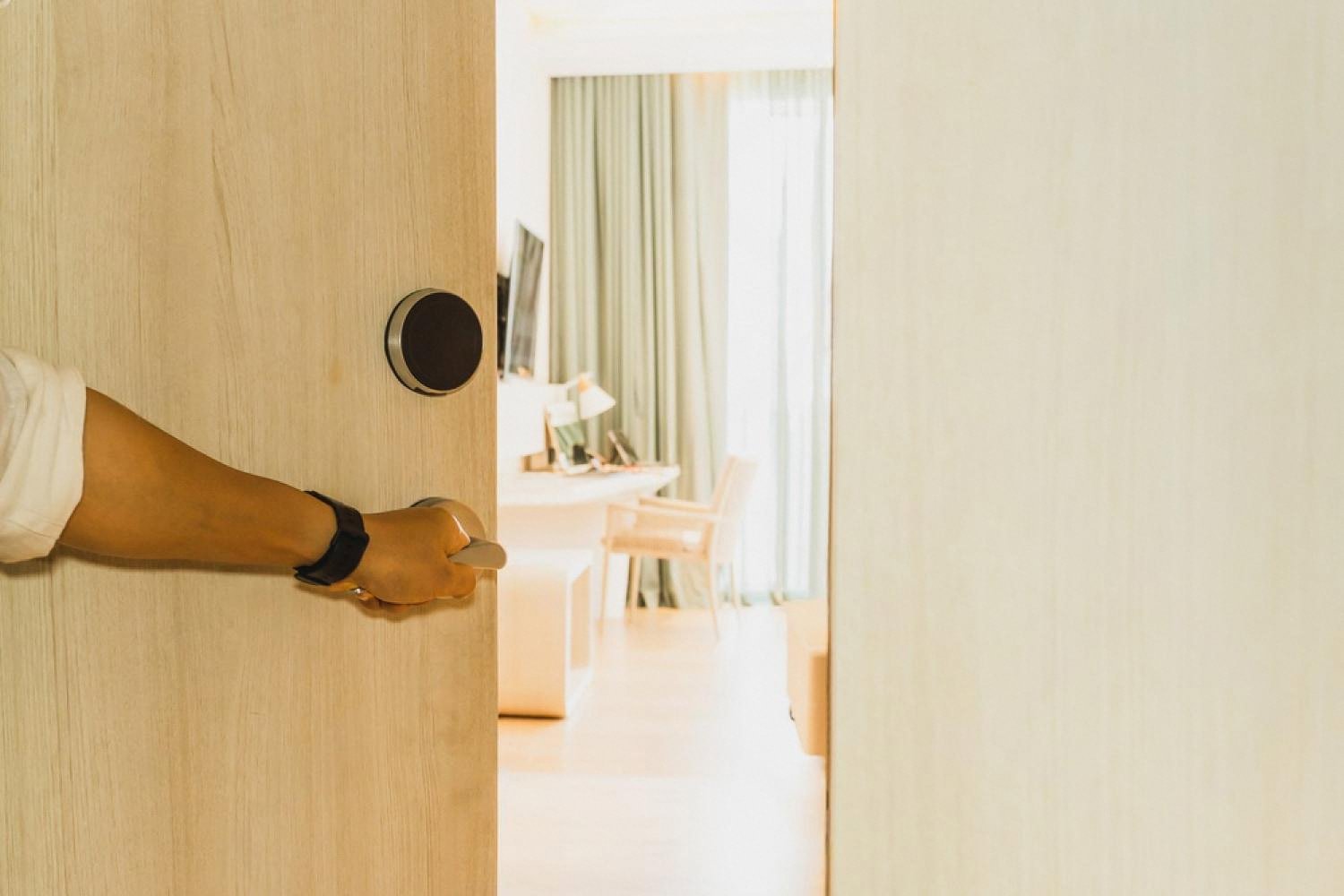 Guest opening a hotel room door after automated document check-in at a Dubai property